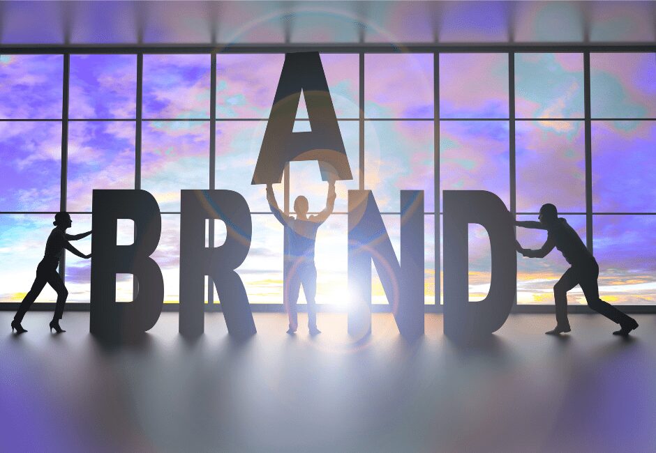 Silhouettes of people assembling large letters spelling BRAND, symbolizing Agile Solutions’ collaborative process for building strong, affordable, purpose-driven brand identities for service businesses.